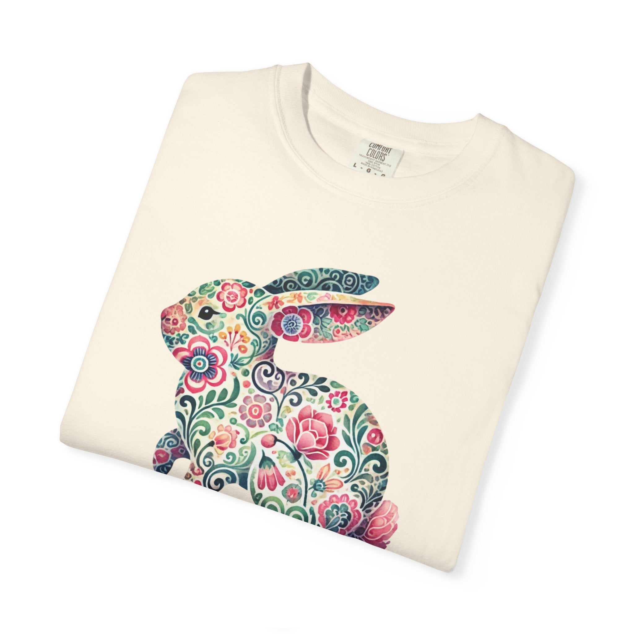 Folded cream-colored sweatshirt with a colorful floral bunny design on a white background