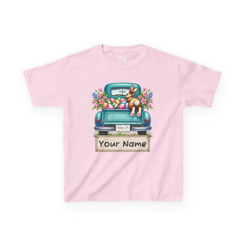 Pink t-shirt with a graphic of a blue truck, dog, and Easter eggs on a white background.