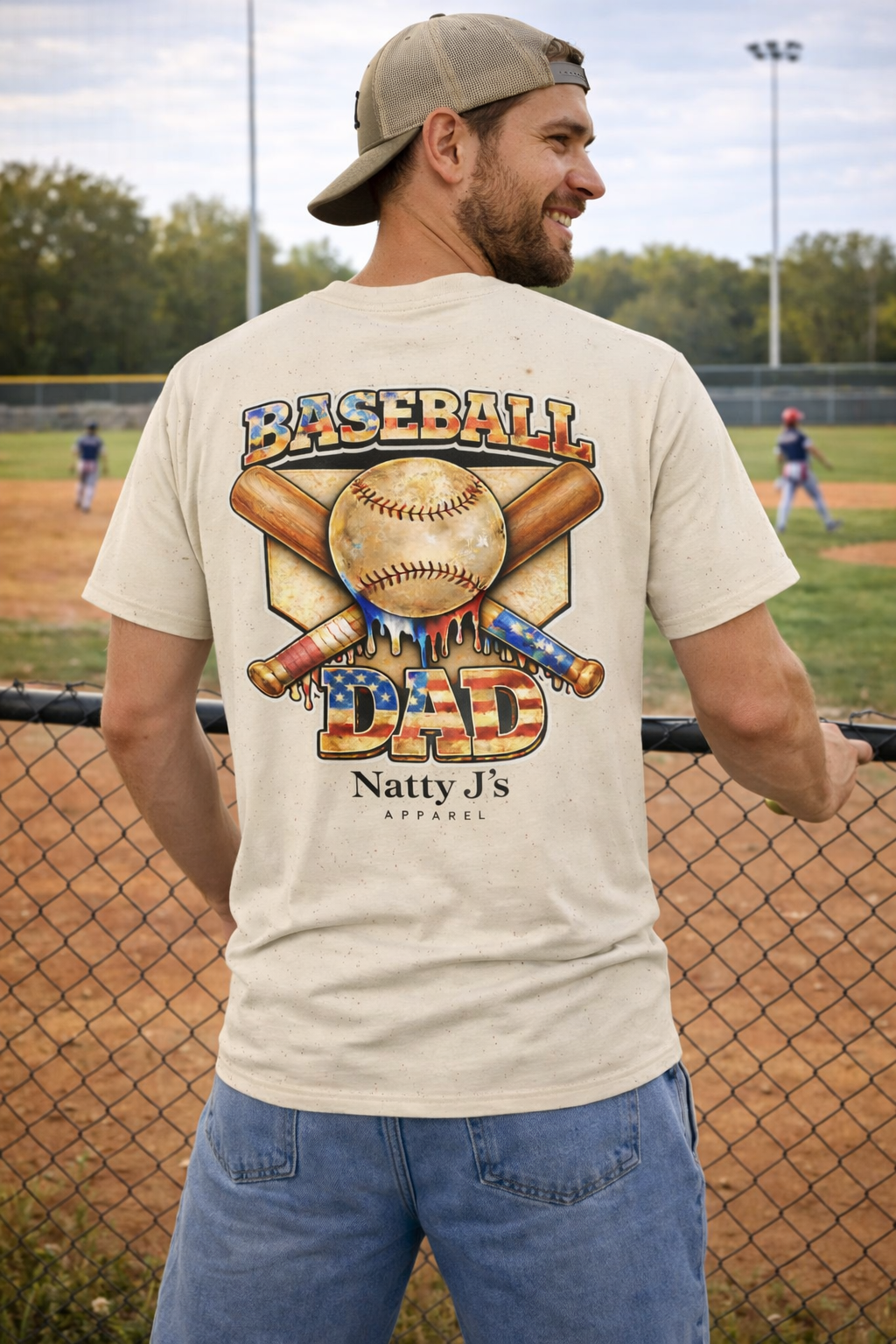 Man wearing a 'Baseball Dad' t-shirt on a baseball field
