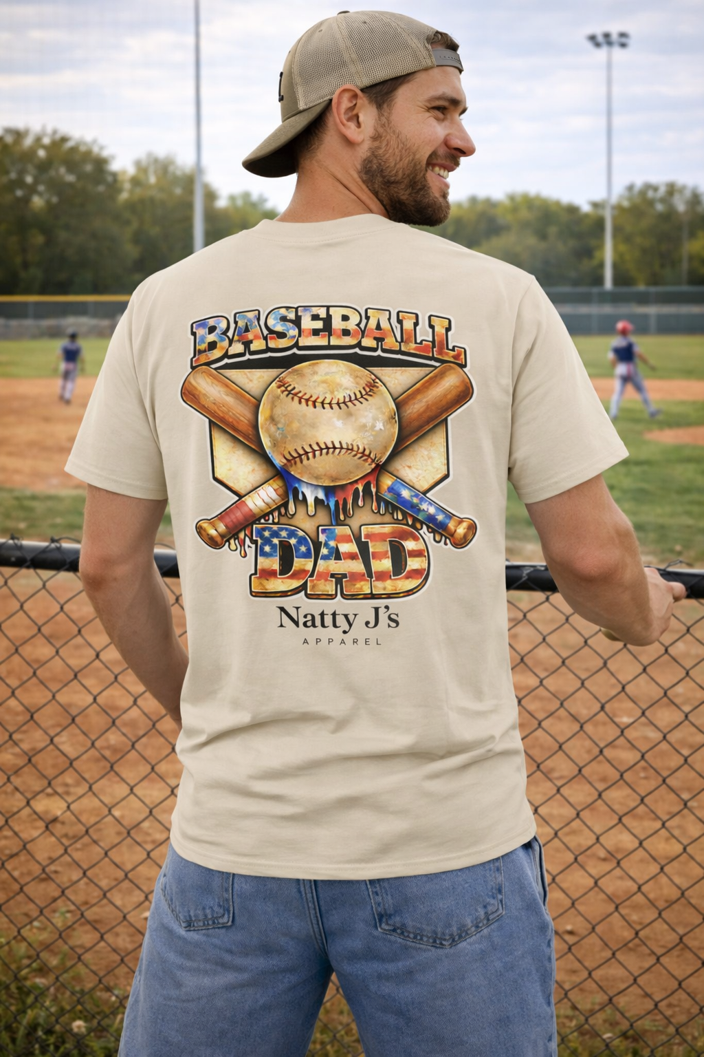 Man wearing a 'Baseball Dad' t-shirt at a baseball field.