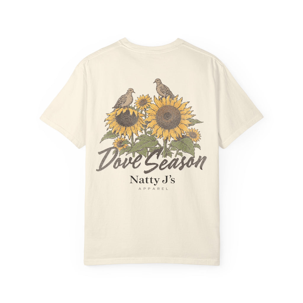 An off-white short-sleeve t-shirt with a vintage-style graphic on the front featuring two birds perched on sunflowers, with the text 'Dove Season' and 'Natty J's APPAREL' printed below.