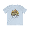 A light blue short-sleeve t-shirt shown from the back, featuring a graphic print of two birds perched on sunflowers with the text 'Dove Season Natty J's APPAREL' in brown.