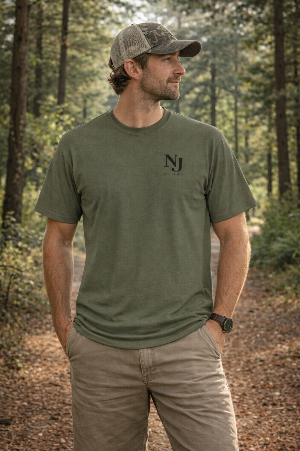 Man wearing a green t-shirt with 'NJ' logo in a forest setting