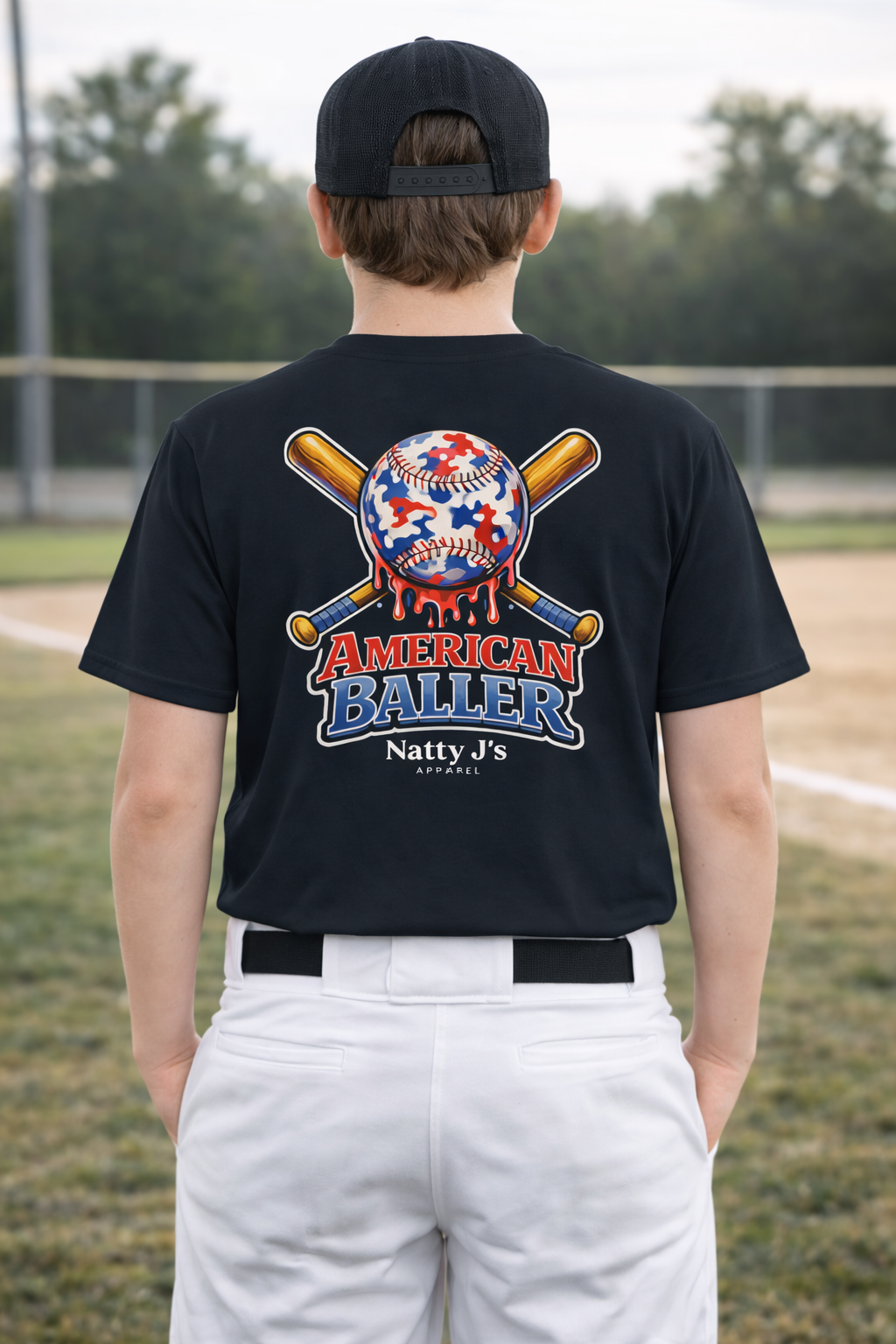 Person wearing a black t-shirt with 'American Baller' design on a baseball field