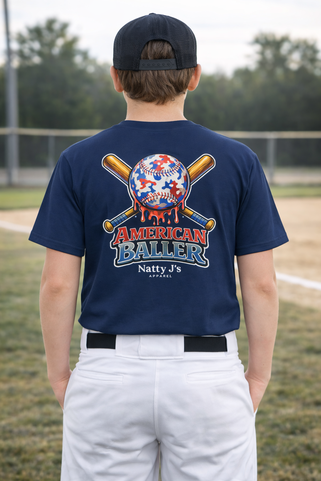 Person wearing a navy blue t-shirt with 'American Baller' design on a baseball field.