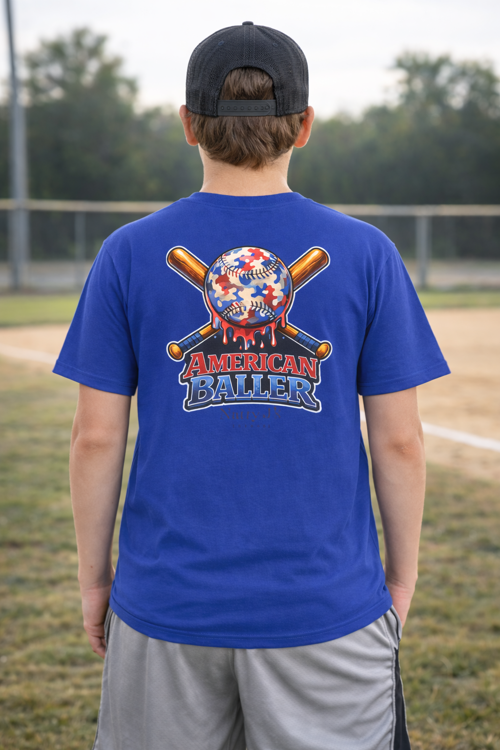 Person wearing a blue t-shirt with 'American Baller' design on a baseball field