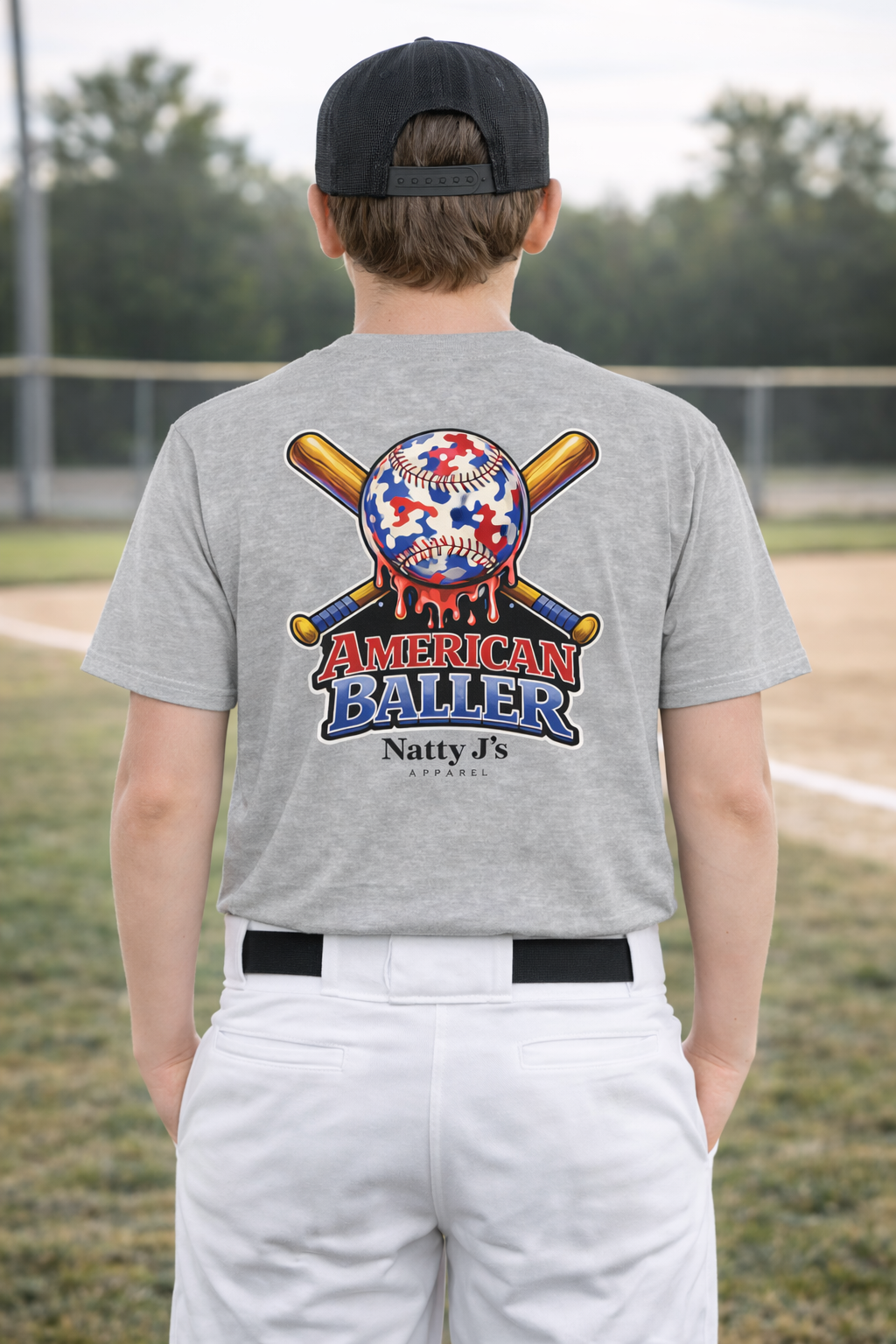 Person wearing a gray t-shirt with 'American Baller' design on a baseball field
