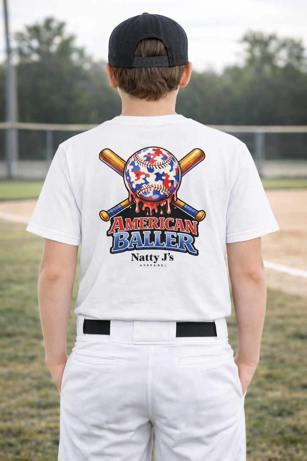 Person wearing a white t-shirt with 'American Baller' design on a baseball field