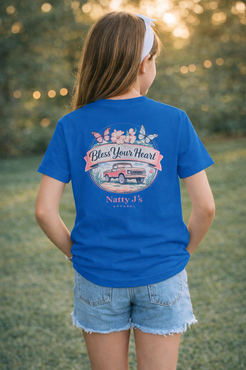 Person wearing a blue t-shirt with a graphic design and text, standing outdoors.