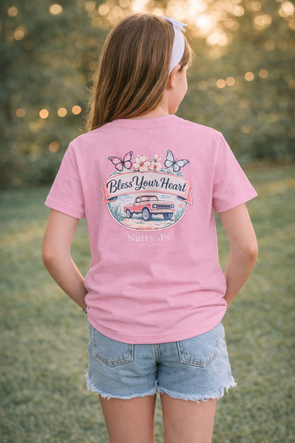 Person wearing a pink t-shirt with a graphic design outdoors