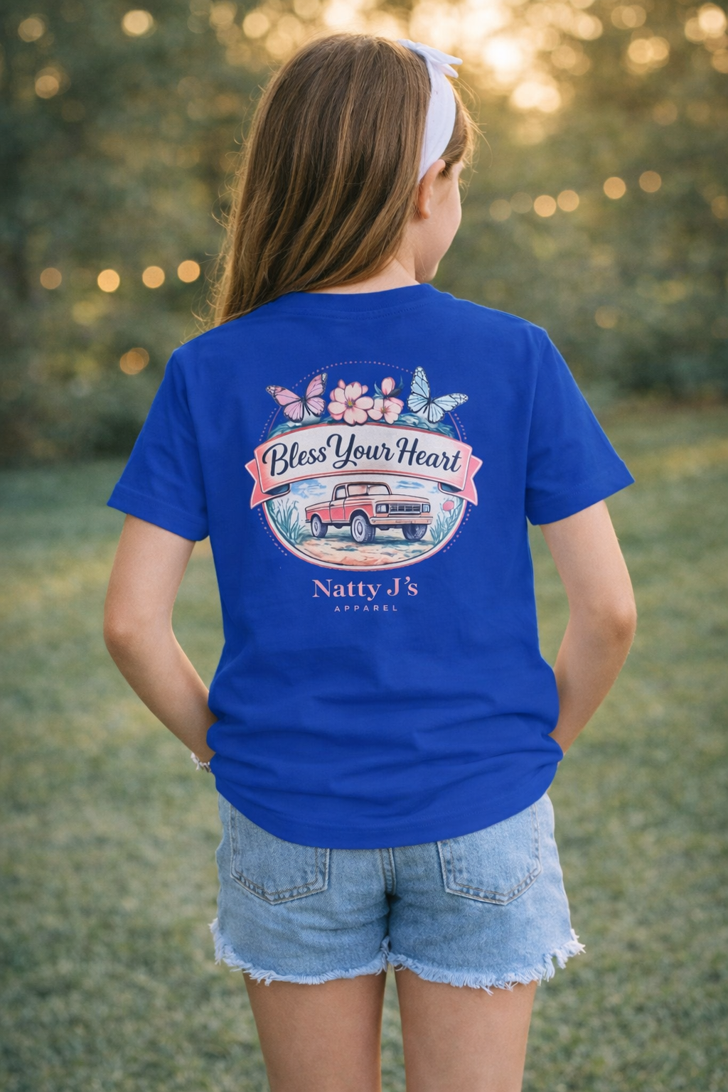 Person wearing a blue t-shirt with a graphic design and text, standing outdoors.