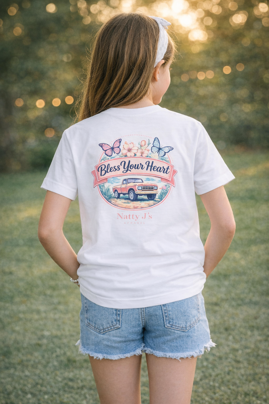 Person wearing a white t-shirt with a graphic design outdoors