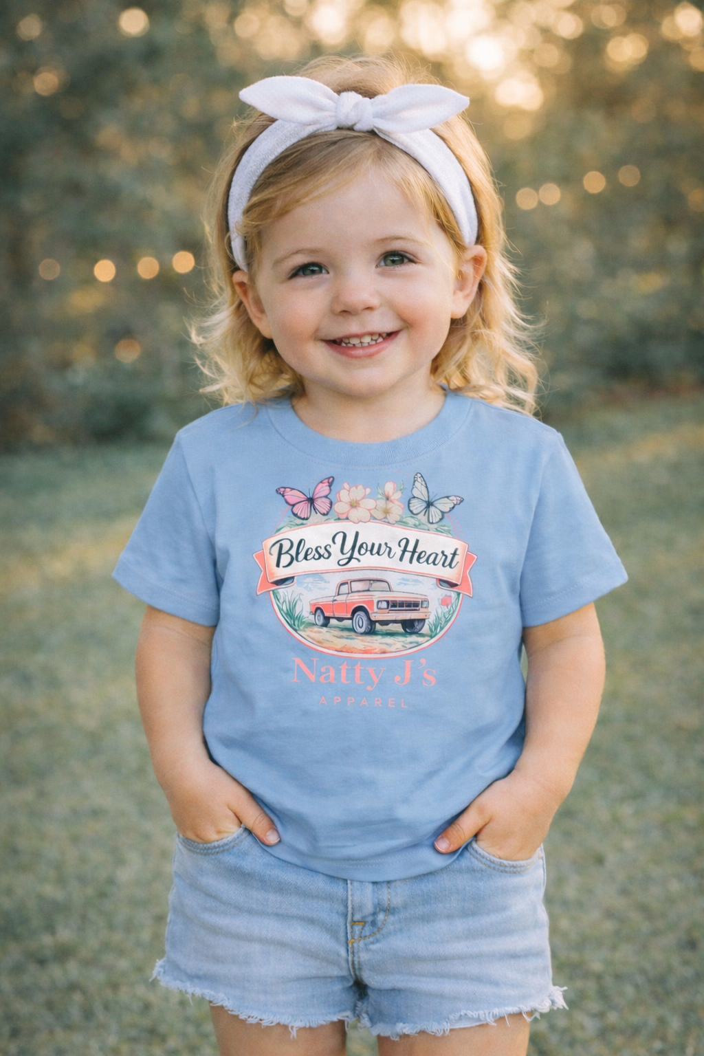 Child wearing a blue t-shirt with a graphic design outdoors