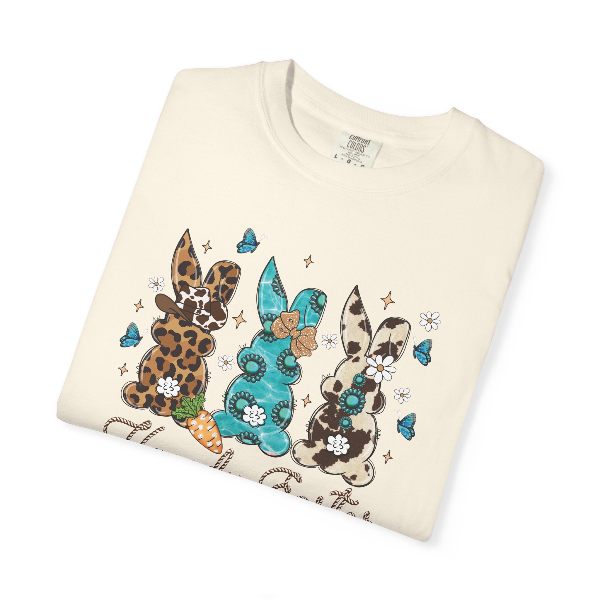 Folded cream-colored sweatshirt with colorful bunny designs on a white background