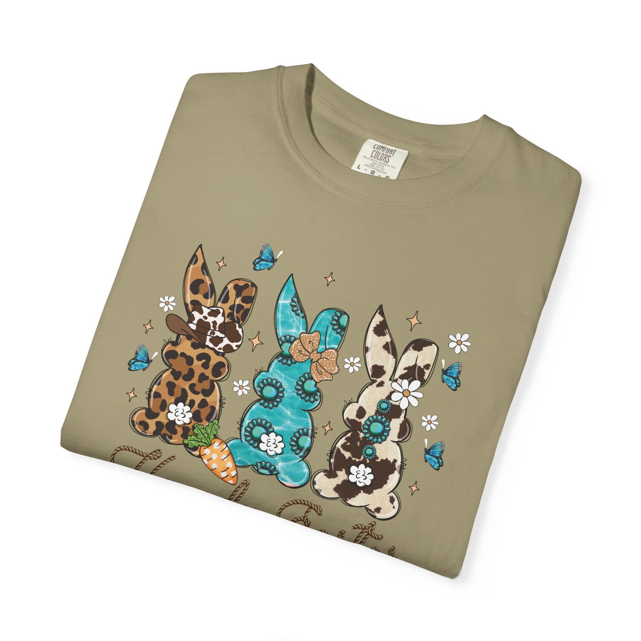 Folded khaki t-shirt with decorative bunnies and flowers on a white background