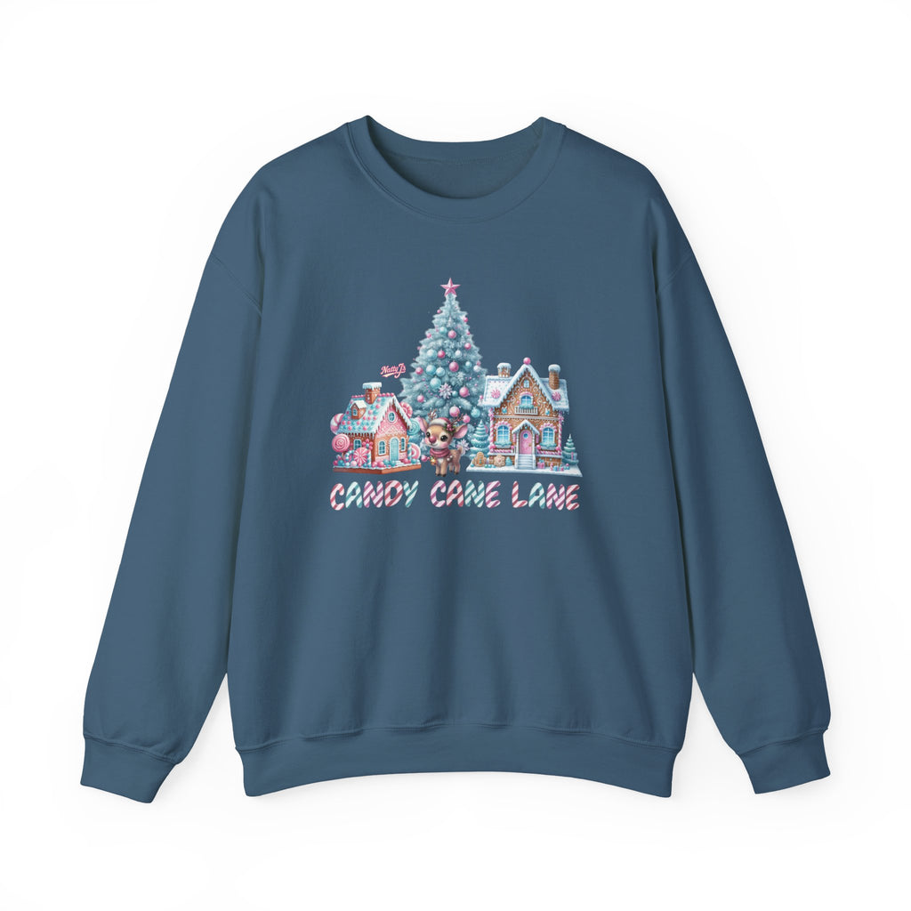 A slate blue crewneck sweatshirt featuring a colorful Christmas village graphic on the chest with a decorated tree, candy cane houses, and the text 'CANDY CANE LANE'.