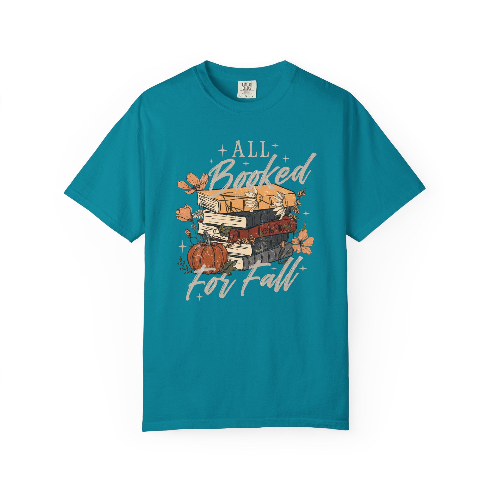 A teal short-sleeve t-shirt with a graphic on the front featuring a stack of books, autumn leaves, a pumpkin, and the text 'ALL Bunked For Fall' in white script, displayed on a clean white background.